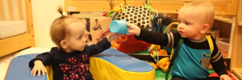 Anderson and Aerolynn Hall playing with each other and passing a toy back and forth