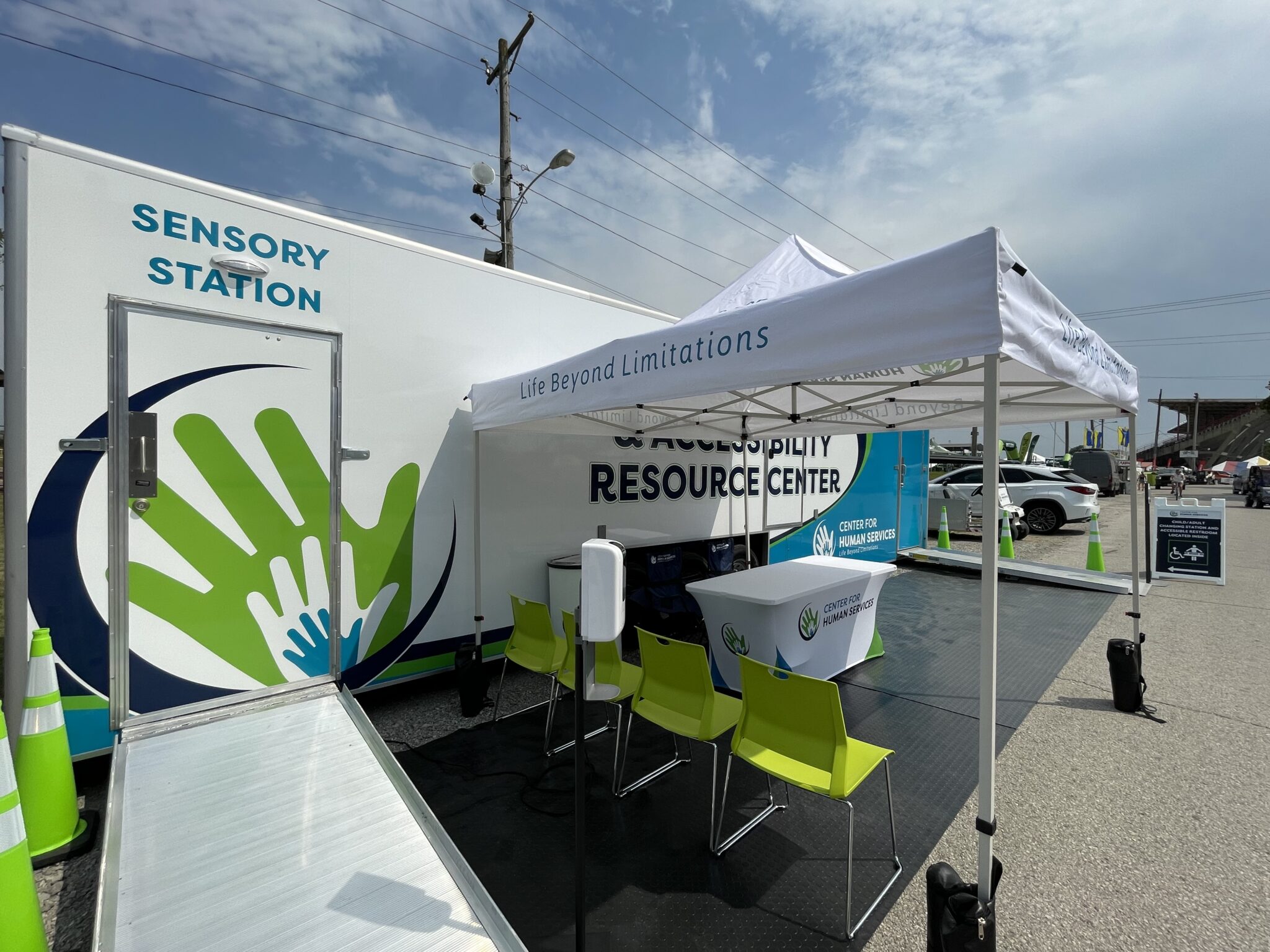 Outdoor sensory station trailer with canopy, seating, table, and resource center signage.