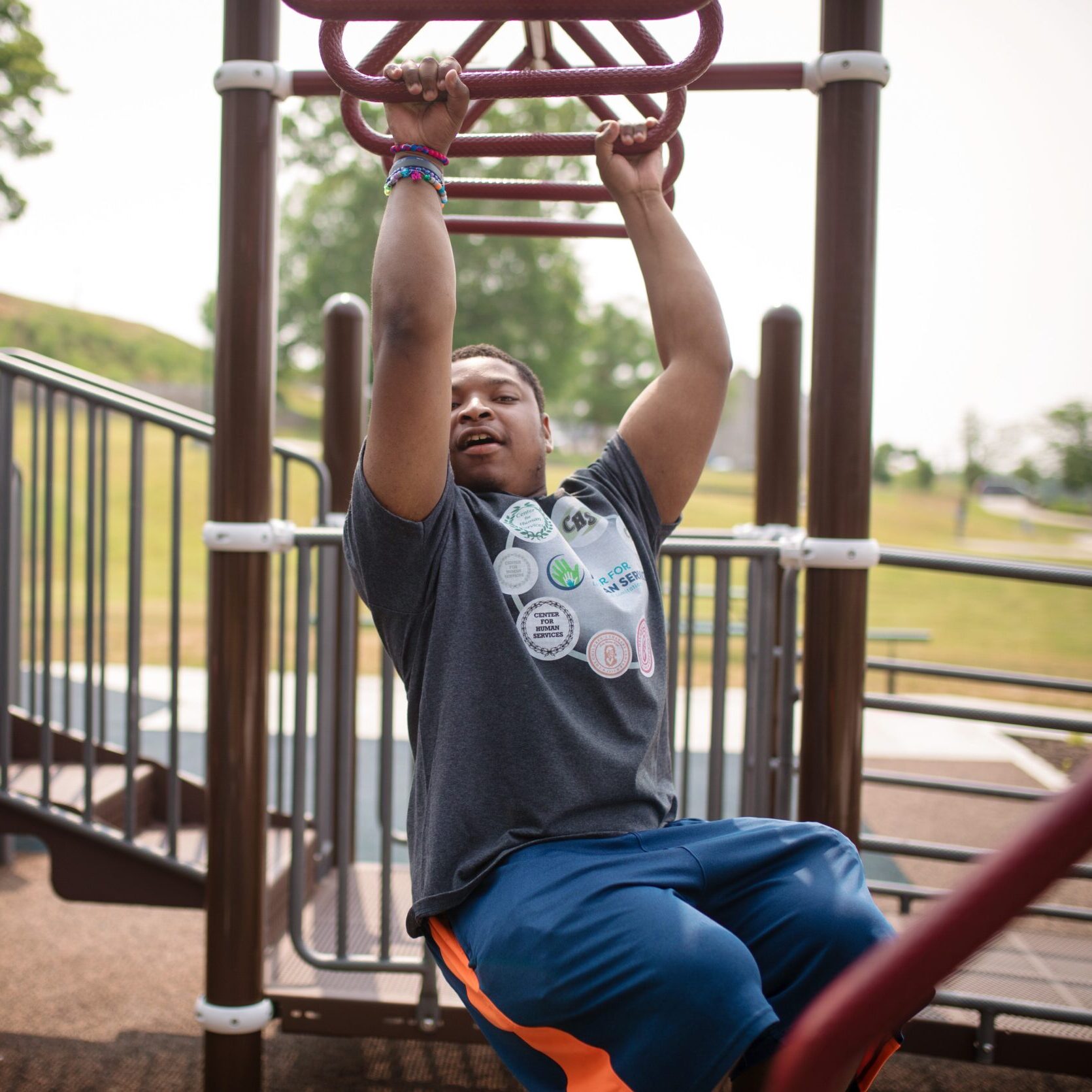 A boy swings from playground equipment