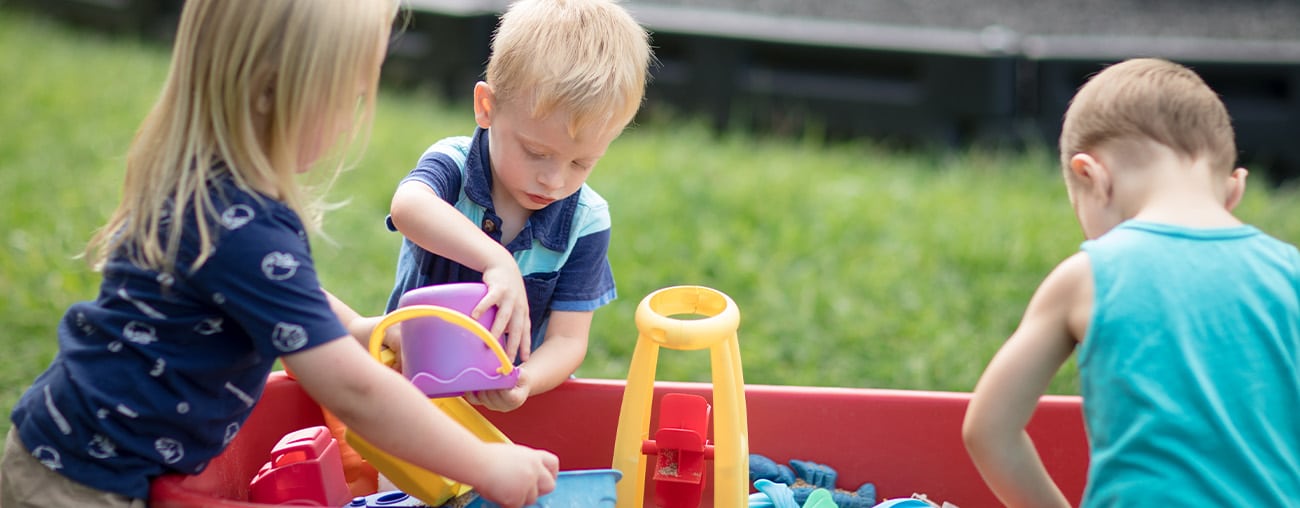 Three kids playing in a sandbox