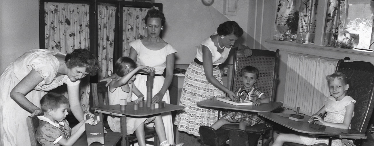 Students playing educational games with their teacher during the early days of CHS