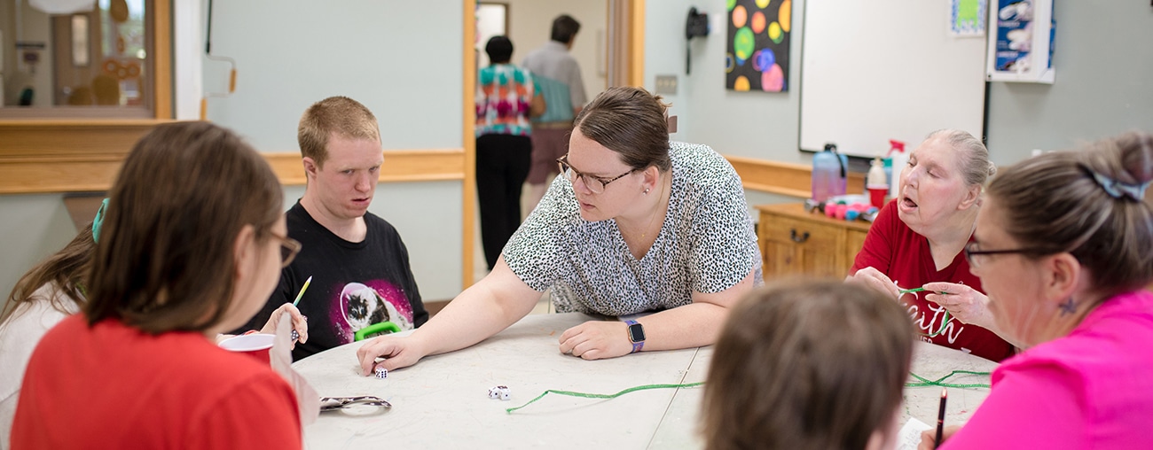 Patients sitting around a table working with a therapist.