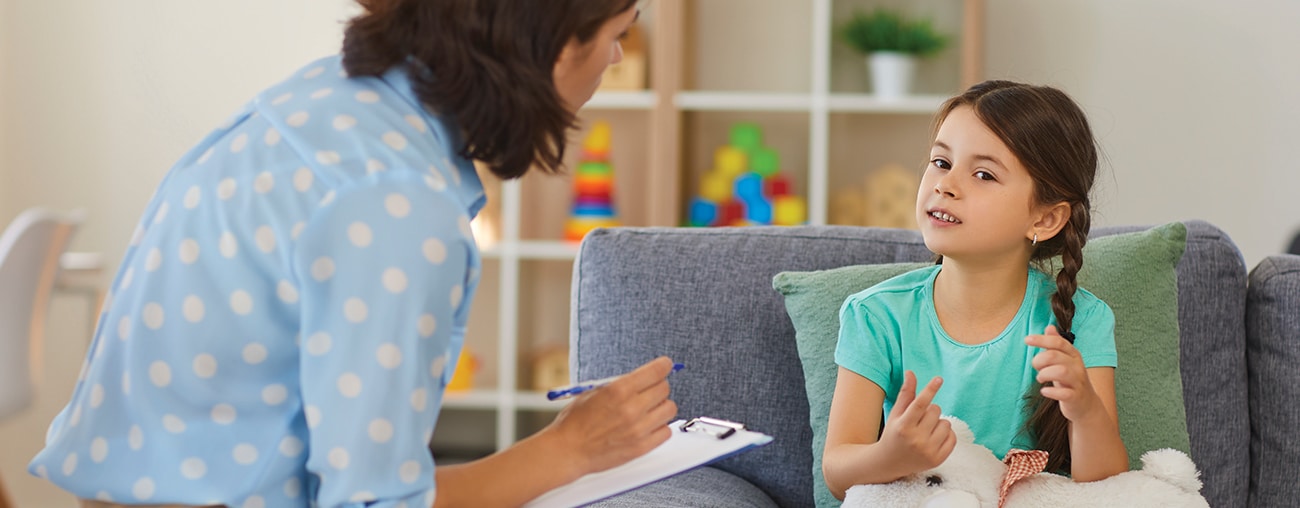 A Center for Human Services employee talking with a young girl client in a home like setting