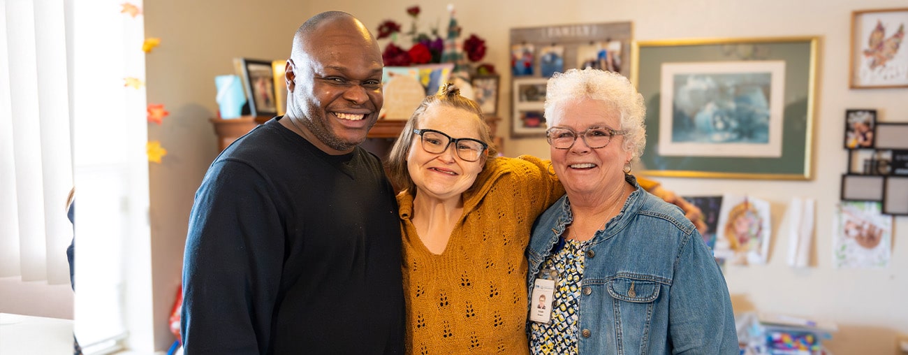 Three smiling people posing for a group photo