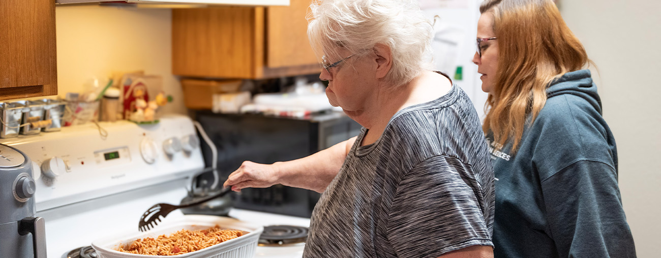 Two women cooking a pasta dish