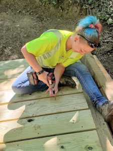 A woman screwing down boards