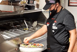 Skylar Todd preparing a dish in a restaurant kitchen.